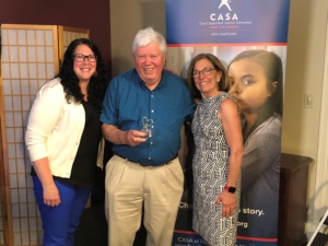 CASA of NH Program Manager Shiloh Remillard, left, and CASA of NH President Marty Sink present CASA Volunteer Advocate Mark Linehan with the 2021 Linda Egbert Outstanding Advocacy Award.